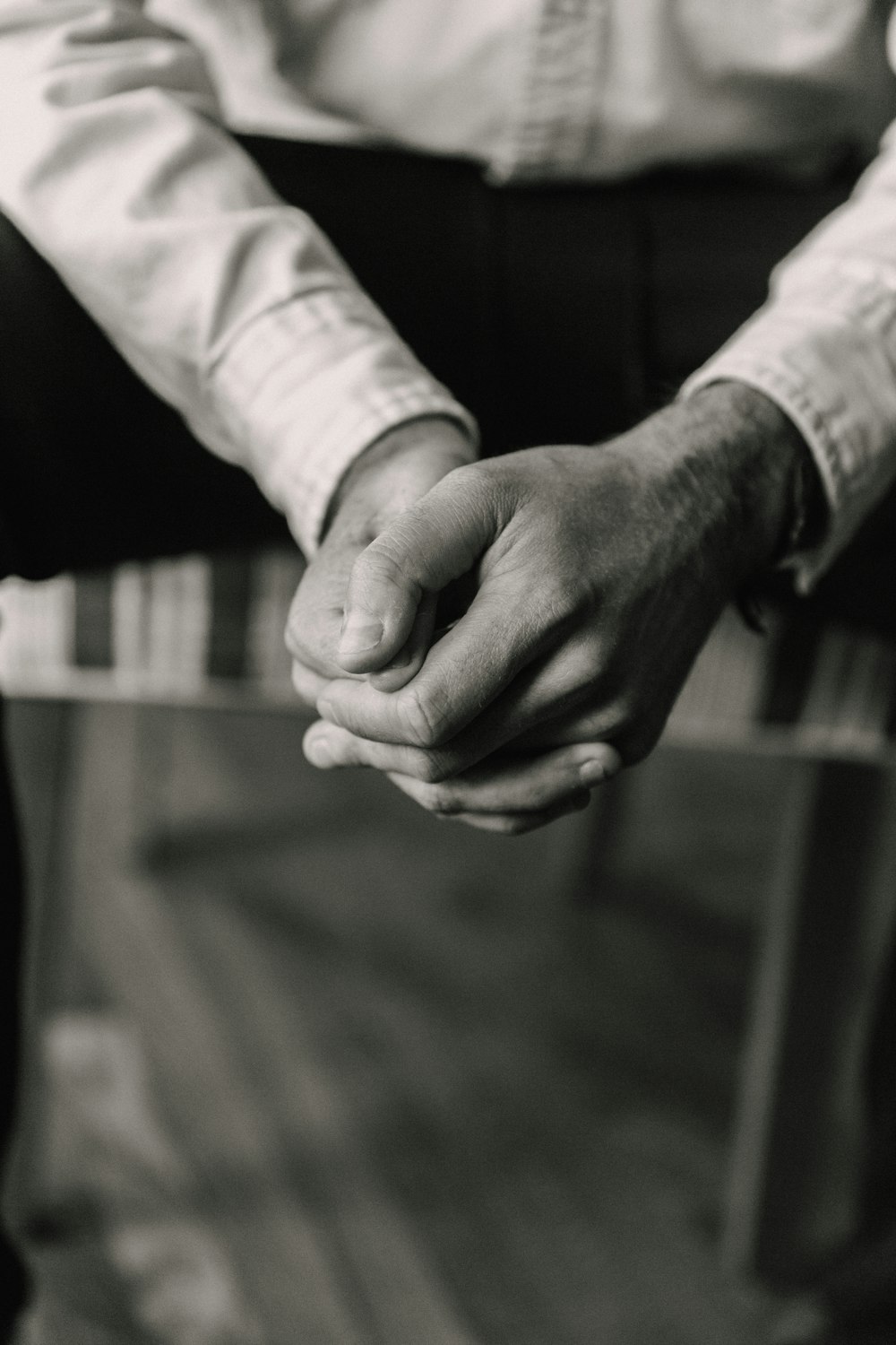 grayscale photo of man and woman holding hands