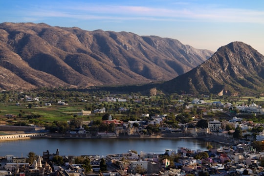 aerial view of city near lake and mountain during daytime in Pushkar India