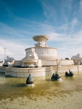 A beautifully carved marble fountain displayed in a serene setting.