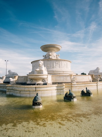 A beautifully carved marble fountain displayed in a serene setting.