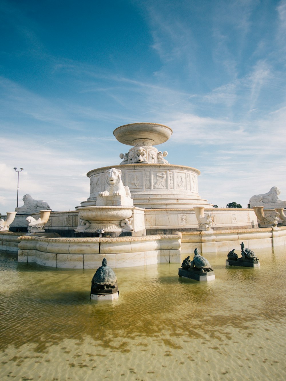 white concrete fountain under blue sky during daytime