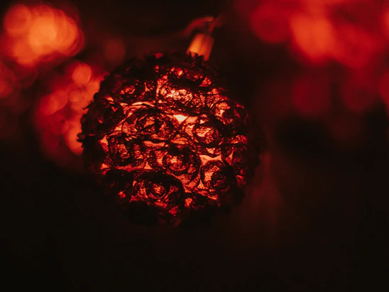 A close-up of a handcrafted copper art piece glowing warmly under soft light.