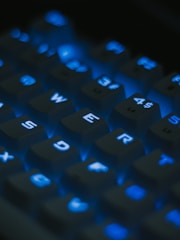 Number and symbol keys glowing softly on a dark mode keyboard.
