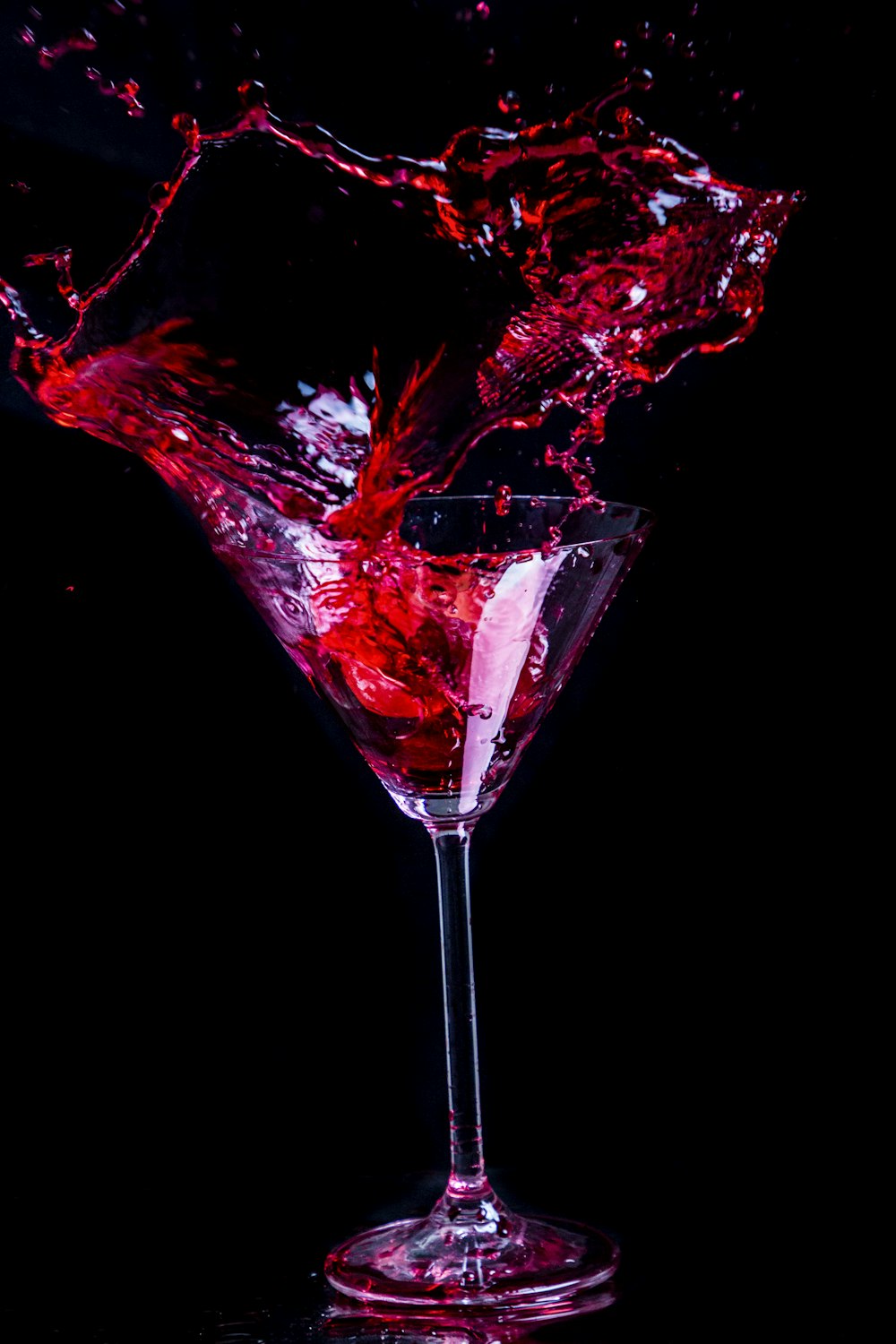 líquido vermelho em copo de vinho transparente