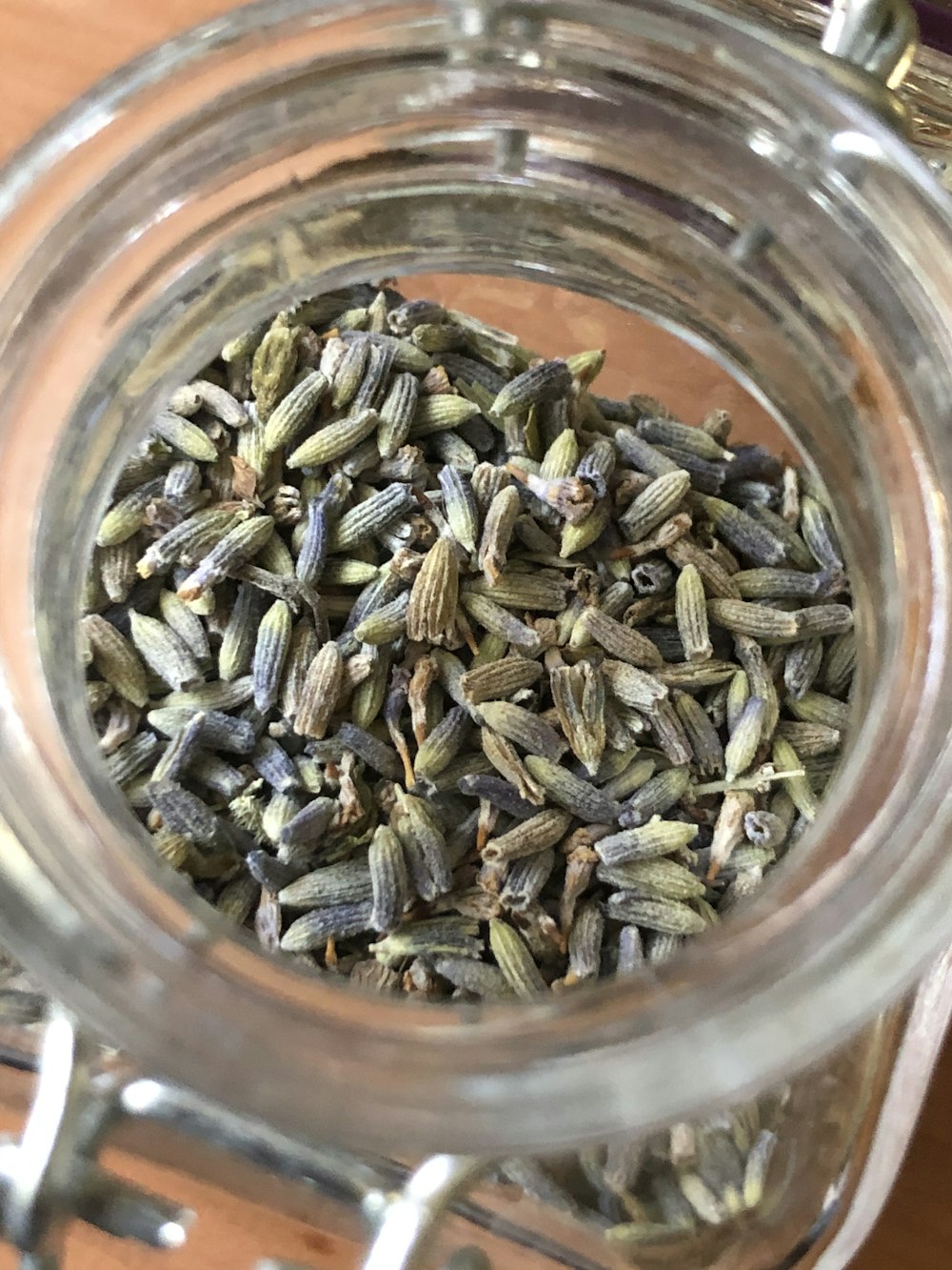 brown and green seeds in clear glass jar