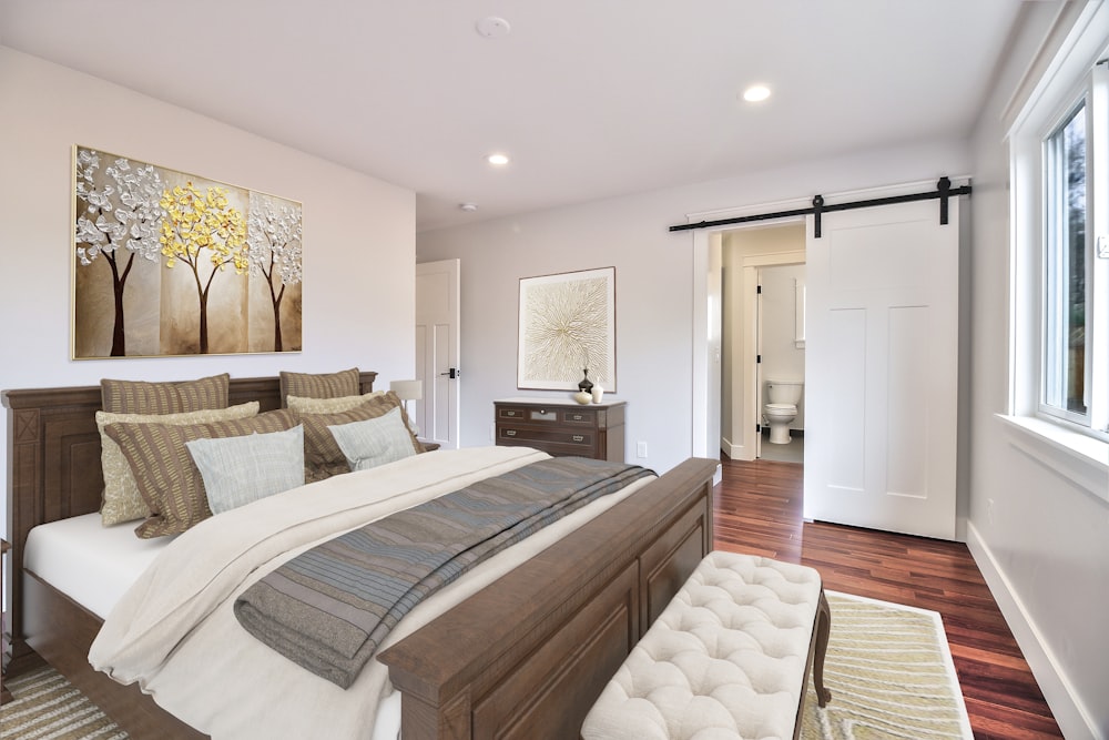 흰색과 회색 침대 린넨이있는 갈색 나무 침대 프레임