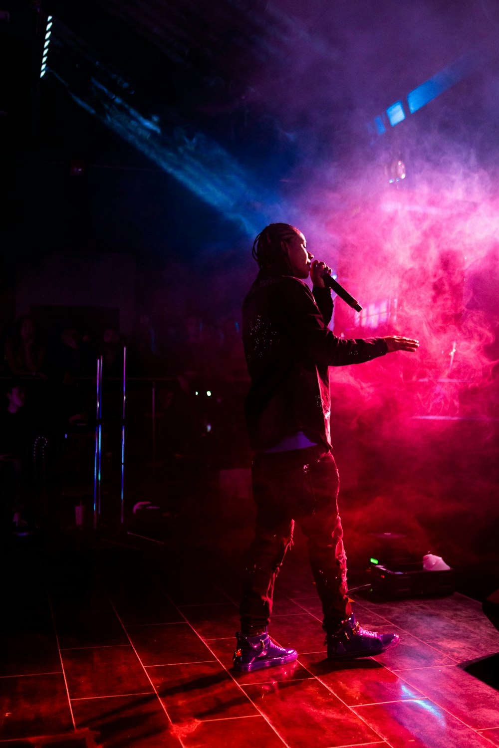 man in black jacket singing on stage