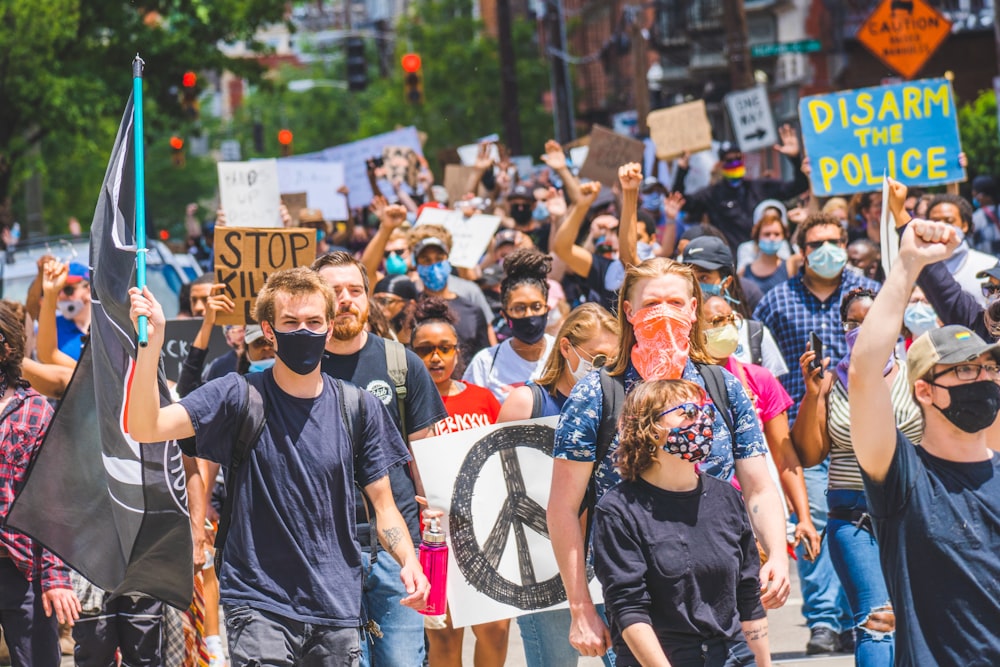 people in black shirts standing on street during daytime