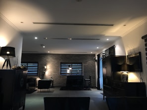 A sleek SPC flooring installation in a modern living room with dark wood accents and bronze fixtures.