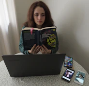 Daniel Mejia working at his desk surrounded by bilingual dictionaries and translation notes.