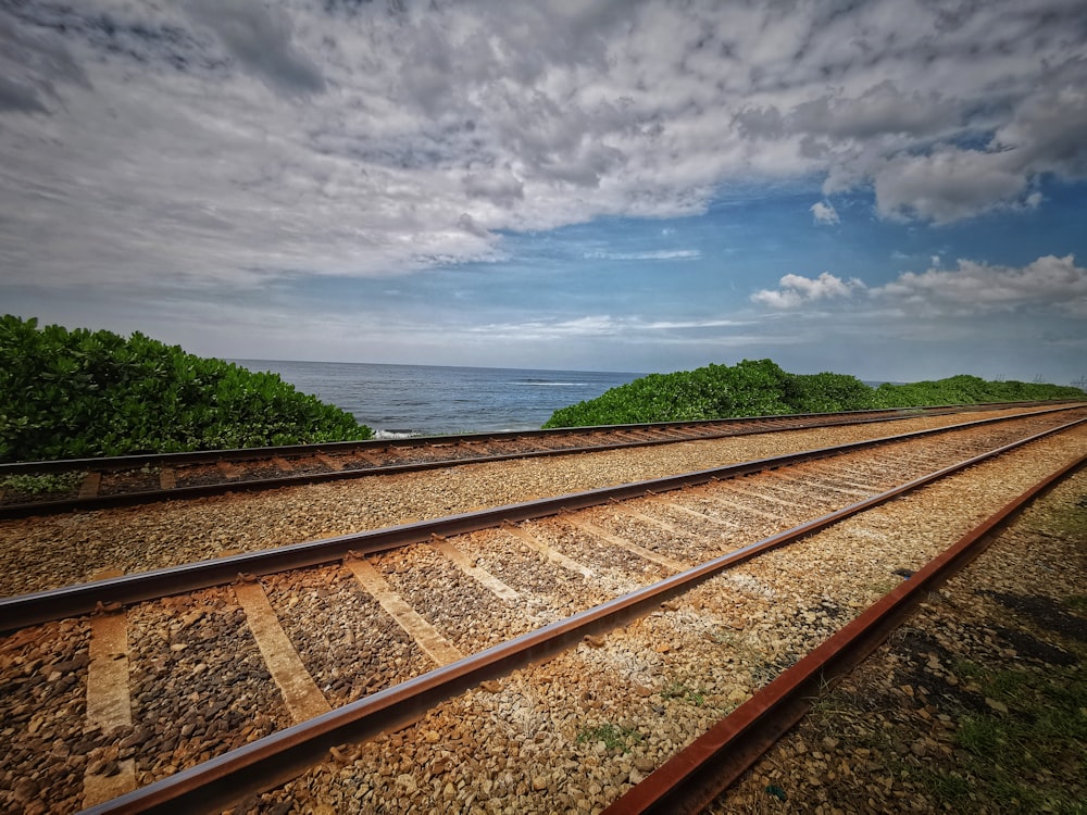 brown train rail under cloudy sky during daytime