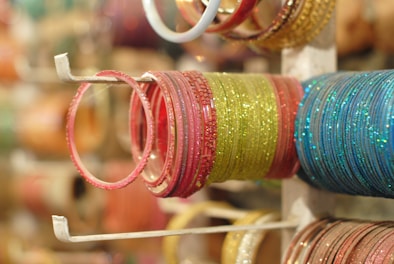 A collection of colorful bangle stands holding various bangles in a bright, well-lit display.