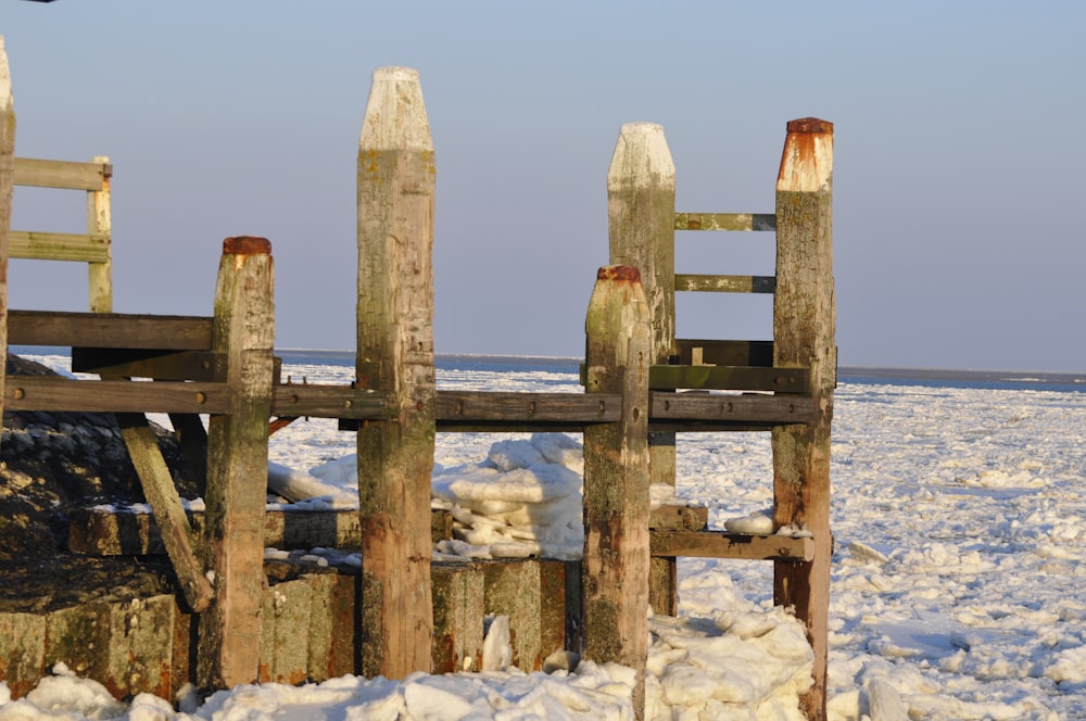 brown wooden fence on white sand during daytime