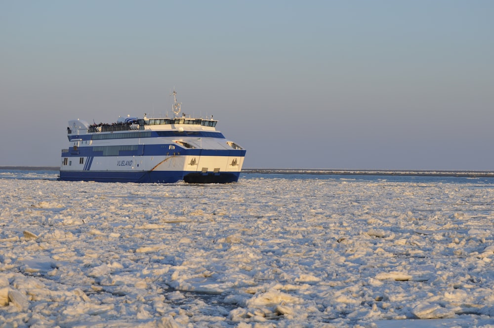 white and blue boat on sea under blue sky during daytime