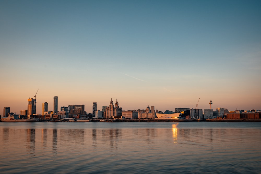 city skyline across body of water during sunset