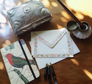 An elegant spread of printed poems and stories laid out on a cream-white table with a gold-accented pen