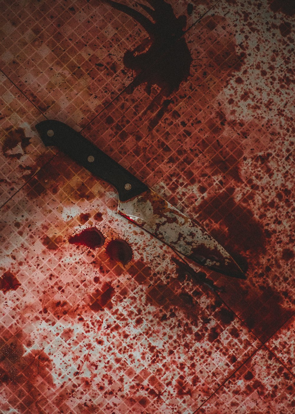 schwarzes Messer mit Griff auf weiß und rot kariertem Textil