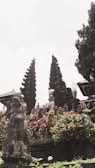 An ancient temple surrounded by lush greenery and flowers.