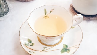 A delicate porcelain cup filled with steaming herbal tea resting on a silk cloth.