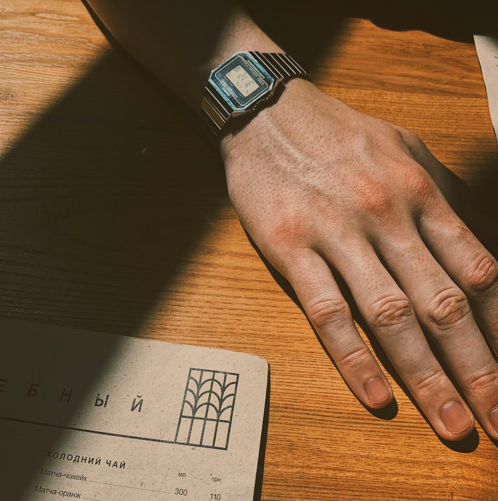 person wearing black and blue smart watch