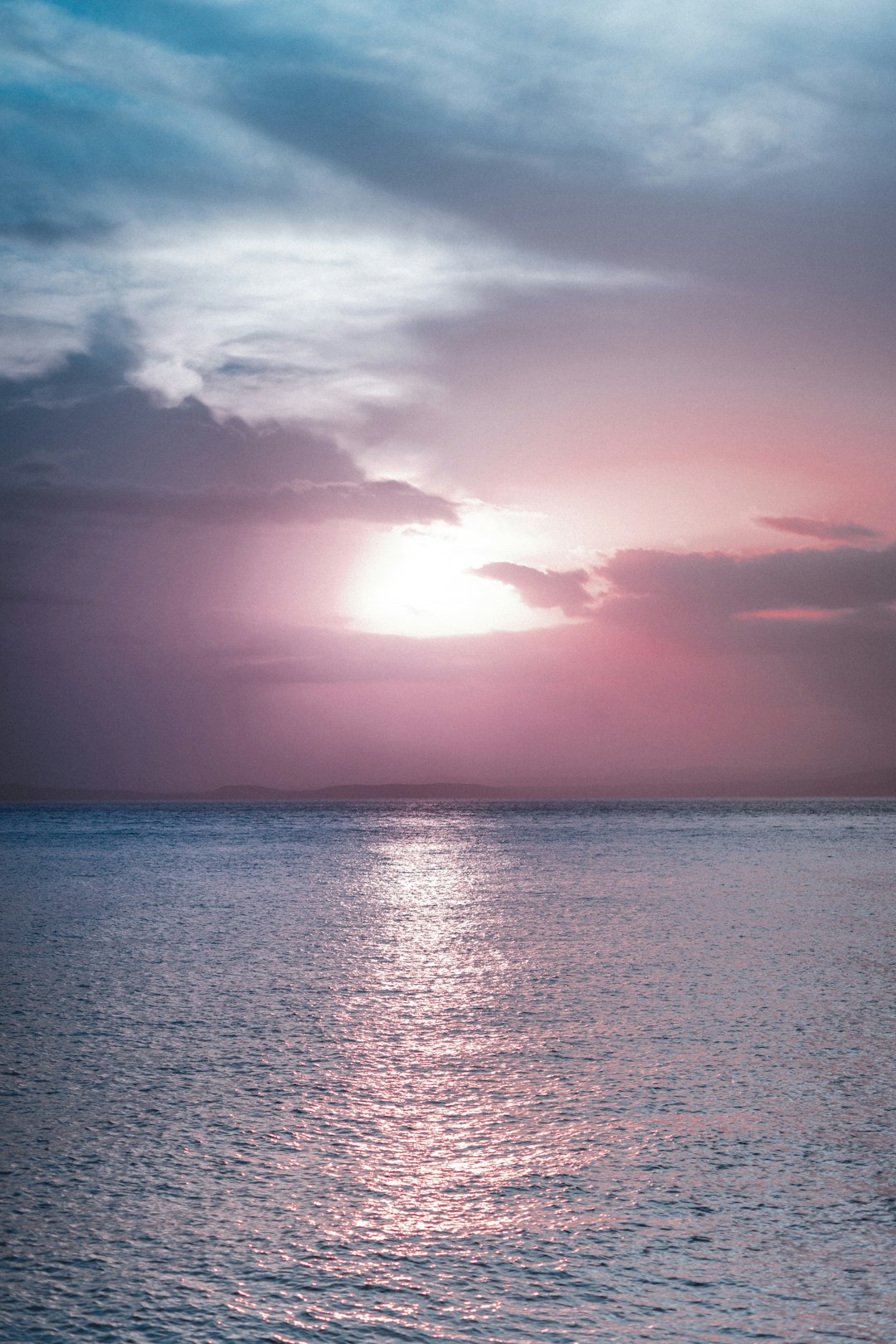 body of water under cloudy sky during sunset