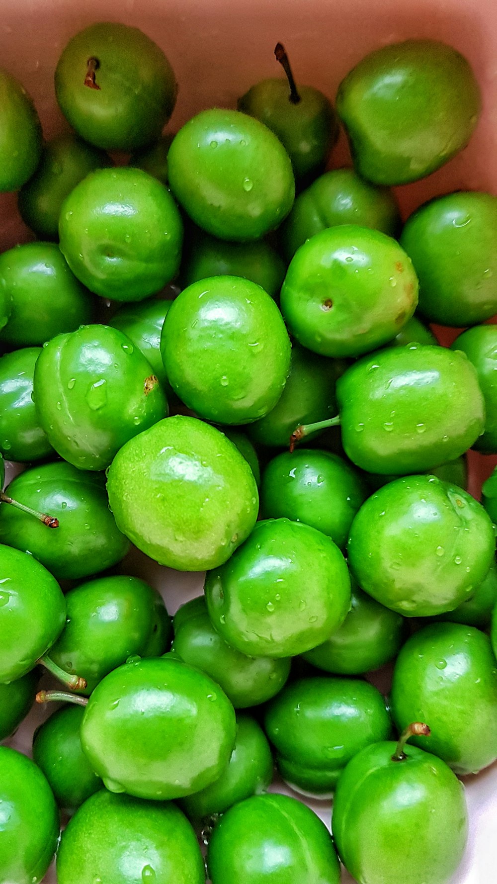 green round fruits on brown wooden table