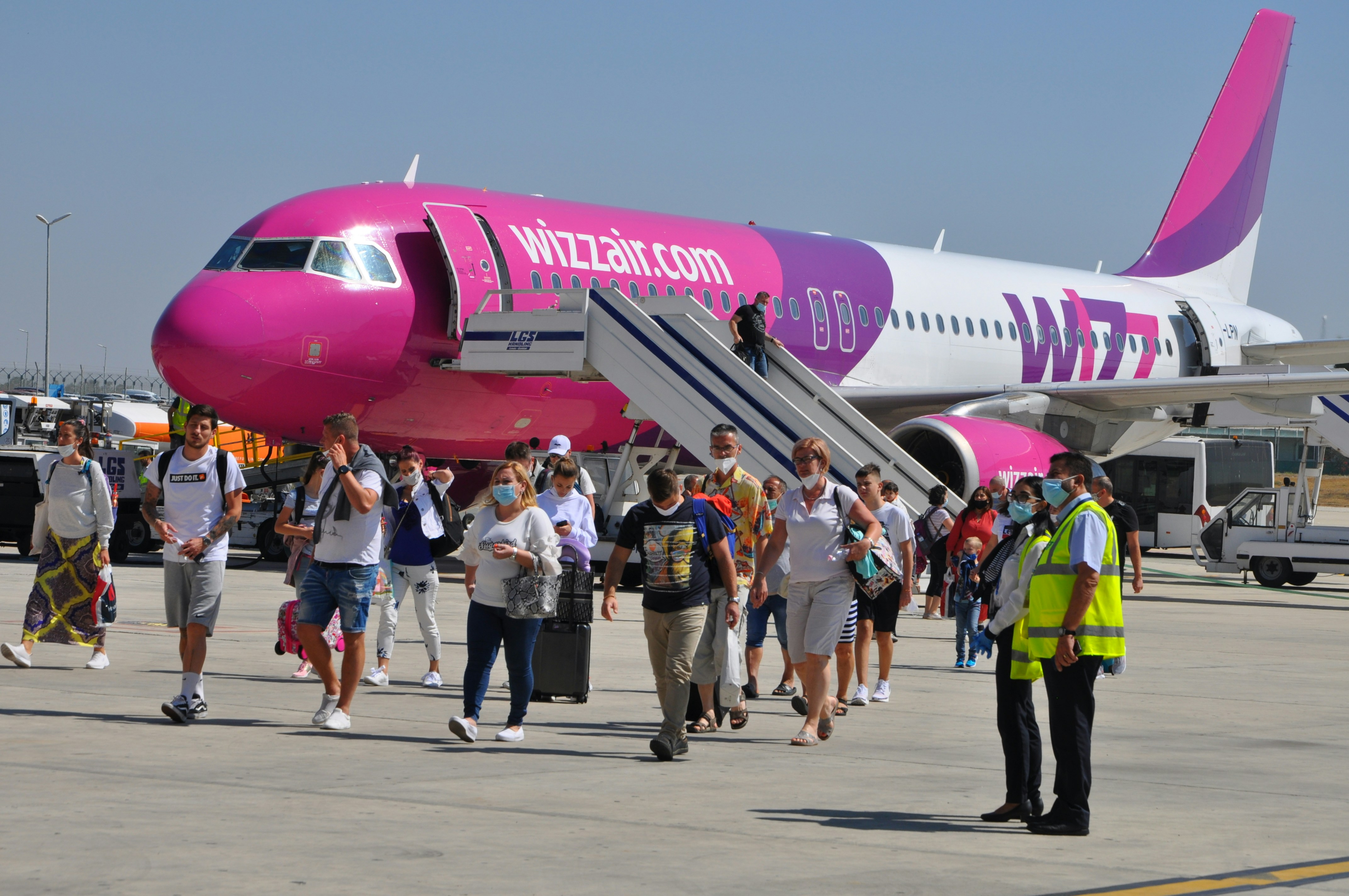 people walking near red and white airplane during daytime, 