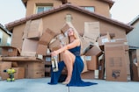woman in blue dress holding brown cardboard box