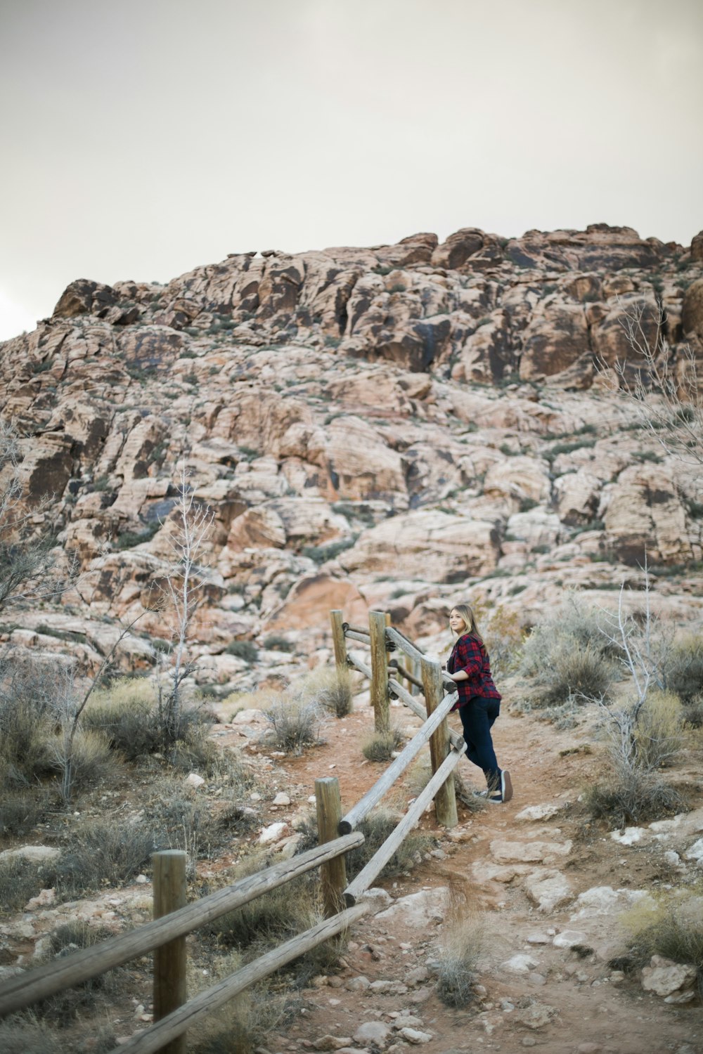 woman in red jacket walking on brown wooden stairs