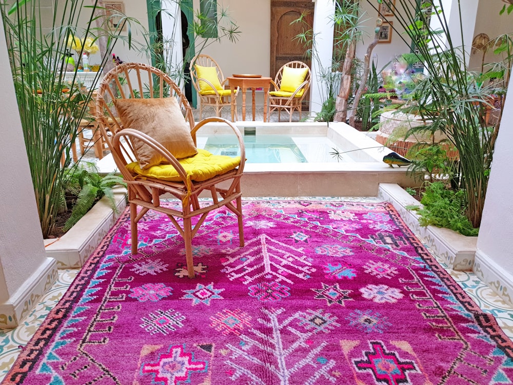 brown wooden armchair on red and white area rug