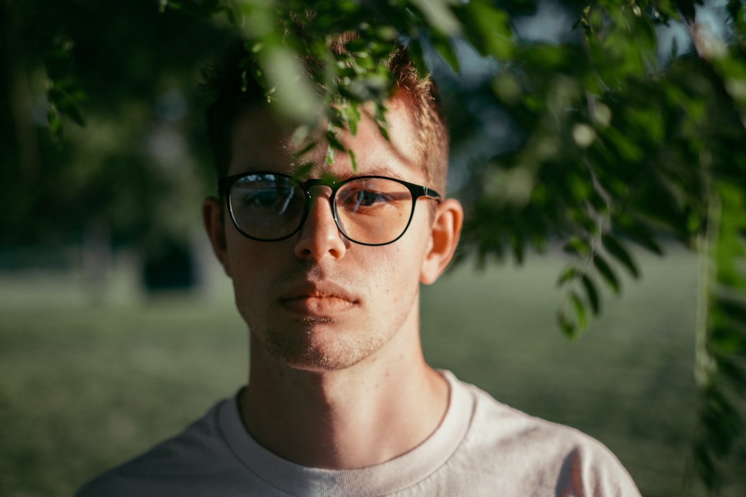 man in black framed eyeglasses and gray crew neck shirt