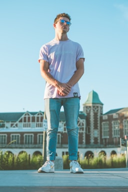 photography poses for men,how to photograph man in white crew neck t-shirt and blue denim jeans standing on green grass field