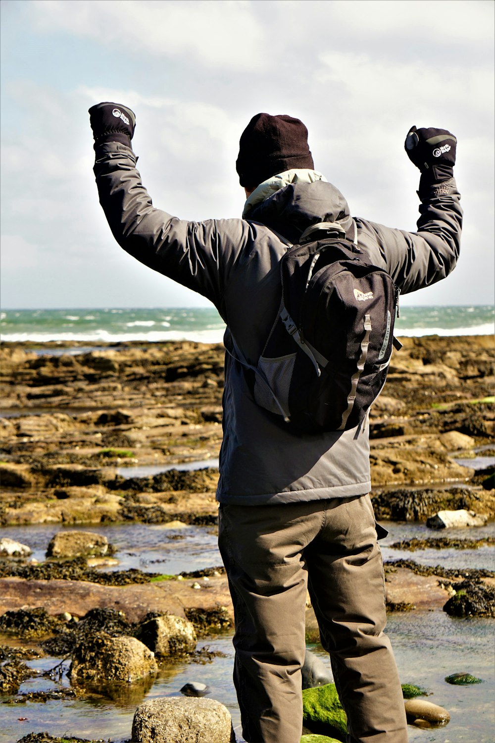 man in black jacket and gray pants standing on brown field during daytime