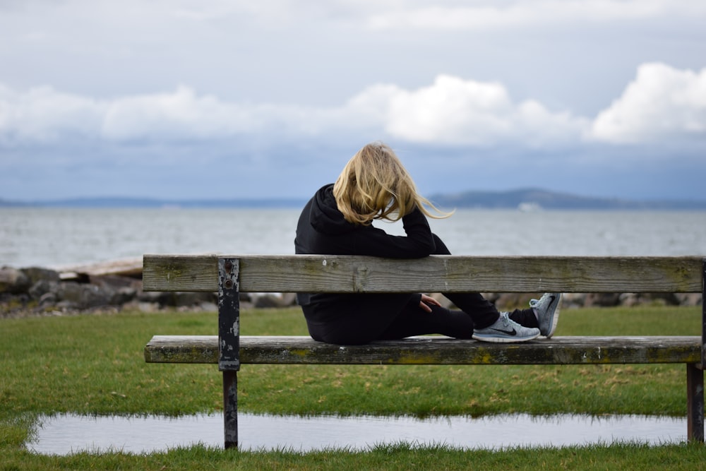 woman in black shirt sitting on bench