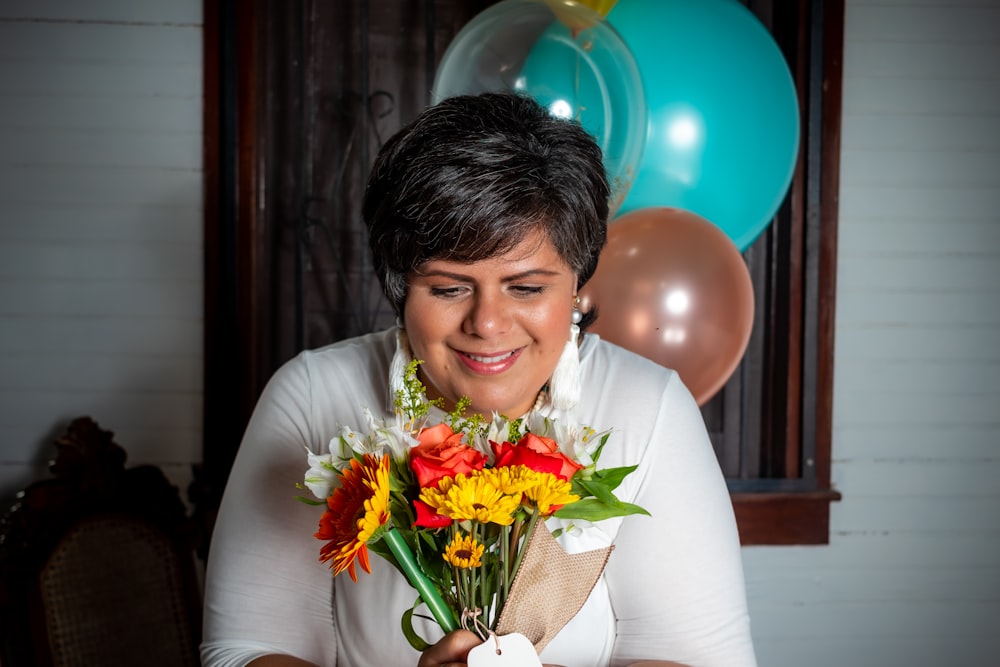 woman in white dress holding bouquet of flowers