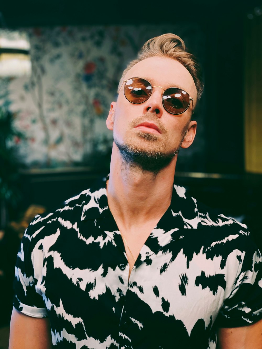 man in black and white floral button up shirt wearing aviator sunglasses