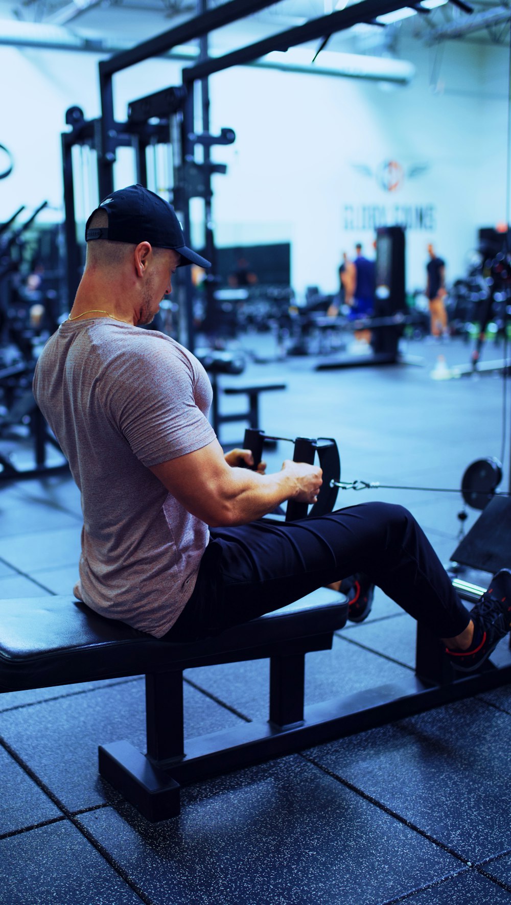 man in gray t-shirt and blue denim jeans sitting on bench