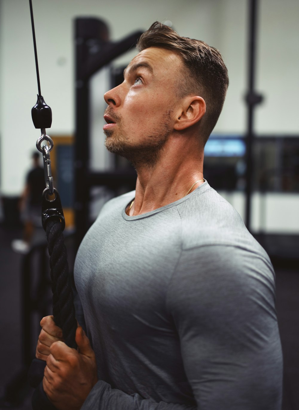 man in gray crew neck shirt holding black rope