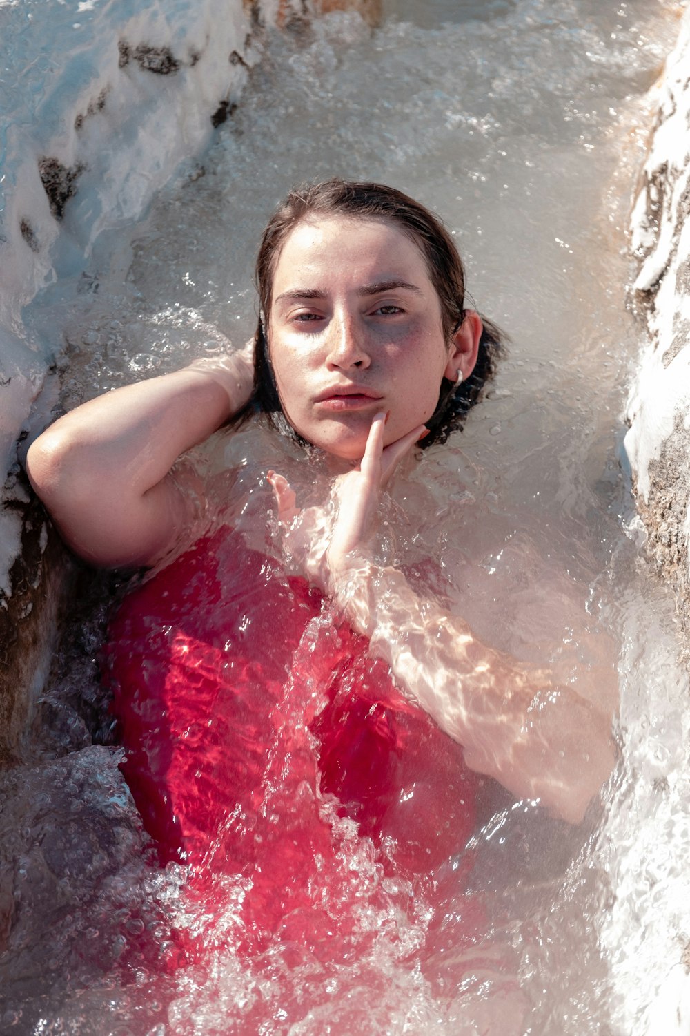 woman in red tube dress lying on water