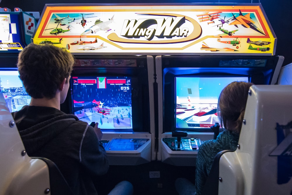 man in black jacket watching on arcade game