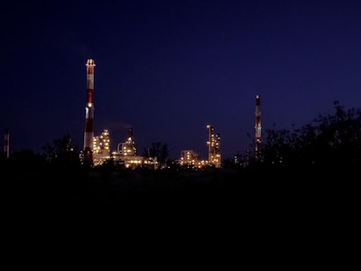 Evening shot of the sawmill facility with warm lights highlighting stacks of wood.