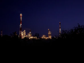 Aerial shot of industrial biomass processing facility at dusk with illuminated structures.