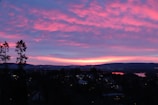 A vibrant sunset over a quiet village landscape.