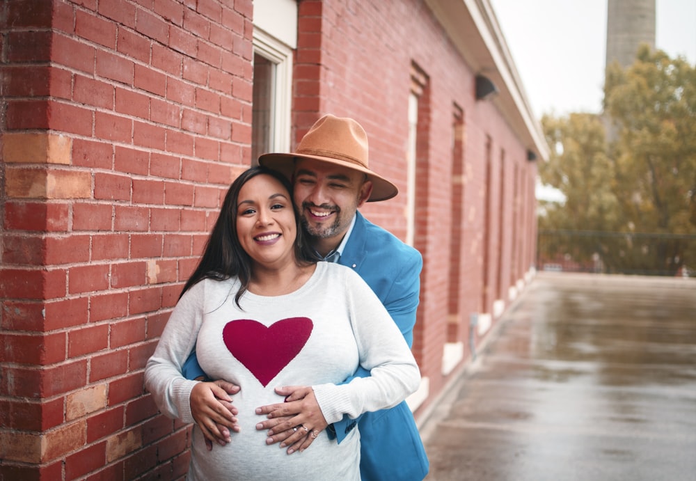 woman in blue and white heart sweater and blue denim jeans wearing brown fedora hat standing