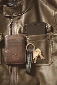 A sleek Faraday bag sitting next to a smartphone and keys.