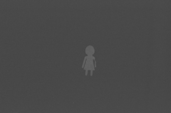 A simple, stylized icon of a person stands alone on a dark background. The figure appears minimalistic, with no facial features or detailed clothing.