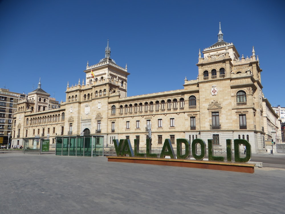 Edificio de hormigón blanco y verde bajo el cielo azul durante el día