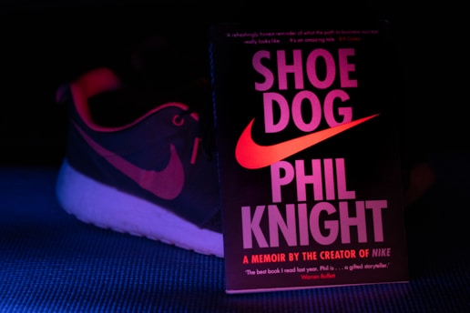 A vintage Nike running shoe beside a notebook filled with handwritten stories and sketches.