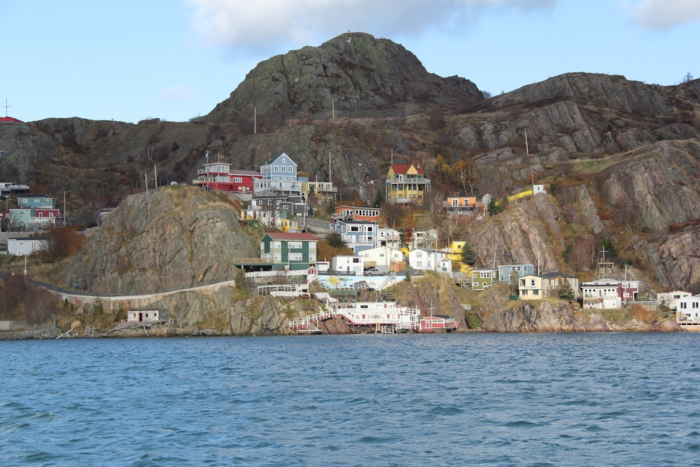 houses on mountain near body of water during daytime