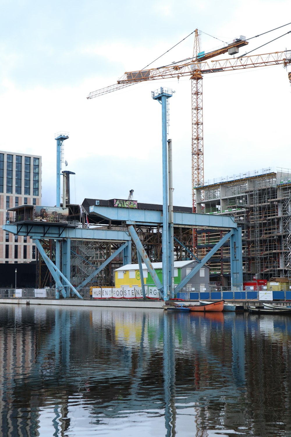 gray metal crane near body of water during daytime